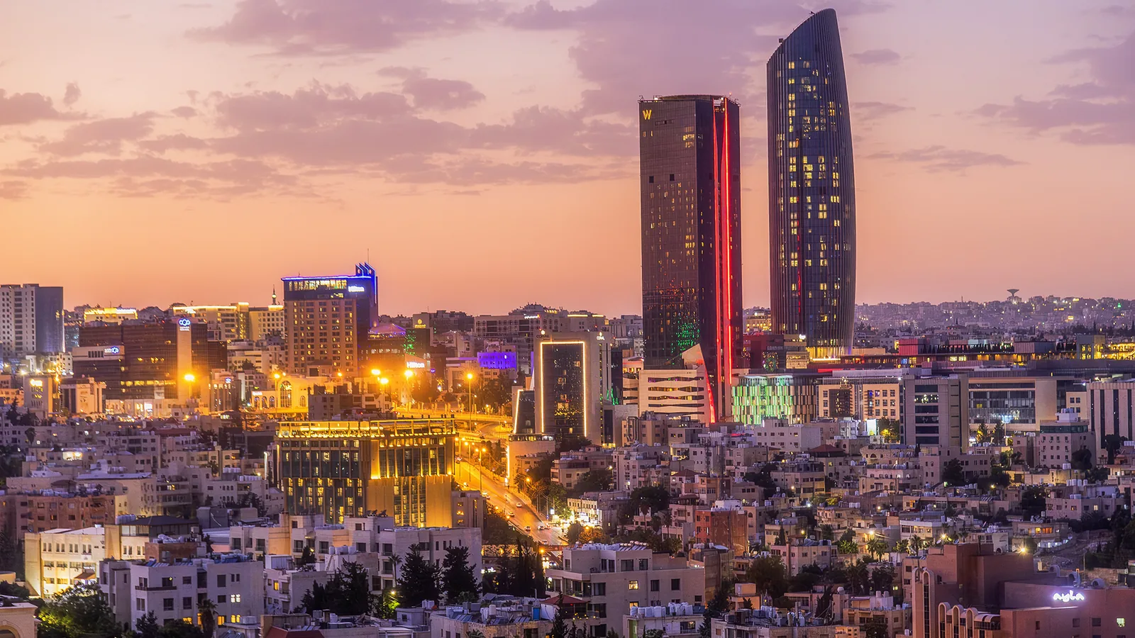 Amman skyline at sunset, with the Abdali towers above the city's hillside neighbourhoods